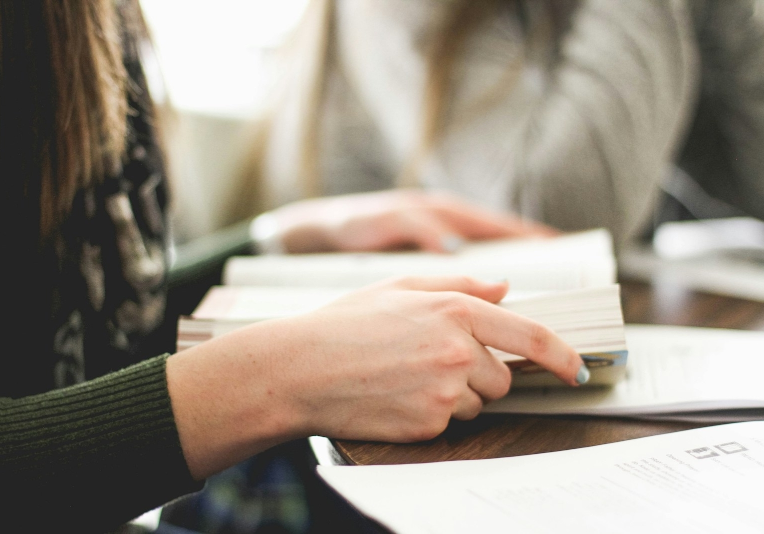 woman sitting on chair in front of table white reading book