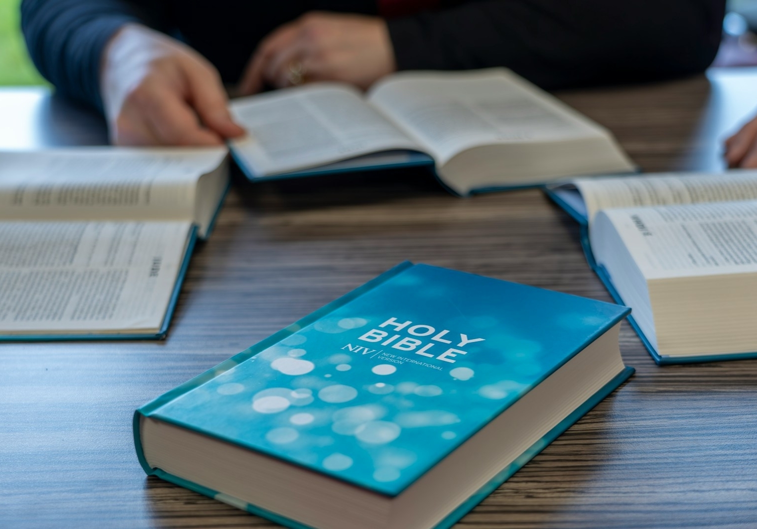 two people sitting at a table with open books